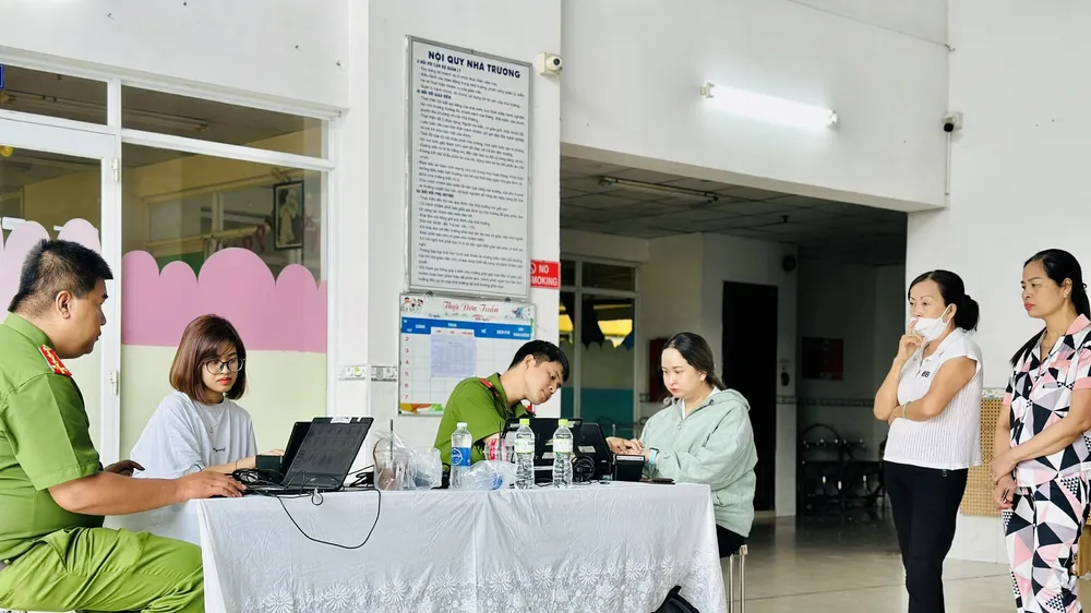 Cán bộ Công an TP Thủ Đức cấp khoản định danh điện tử mức 2 cho người dân. Ảnh CHÍ THẠCH