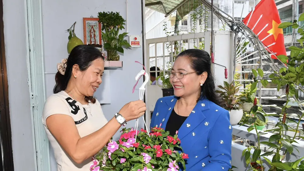 Chủ tịch HĐND TPHCM Nguyễn Thị Lệ tặng hoa cho các hộ dân. Ảnh: VIỆT DŨNG