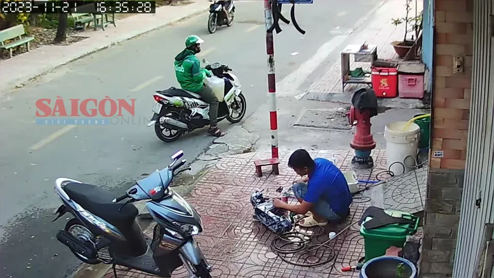 Nghi phạm mang can chứa xăng đứng trước con hẻm vào nhà bà D.