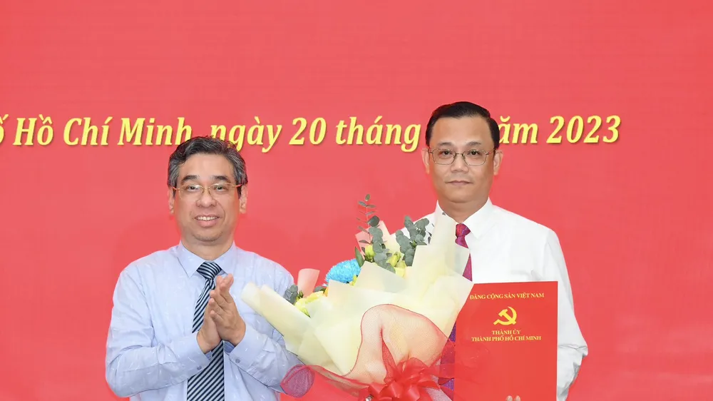 Phó Bí thư Thành ủy TPHCM Nguyễn Phước Lộc tặng hoa chúc mừng đồng chí Cao Sơn Yên. Ảnh: VIỆT DŨNG 