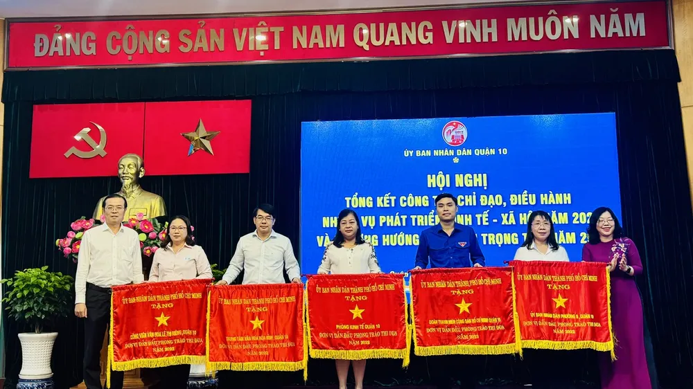 Lãnh đạo quận 10 tặng Cờ thi đua của UBND TPHCM cho 5 tập thể. Ảnh: CHÍ THẠCH 