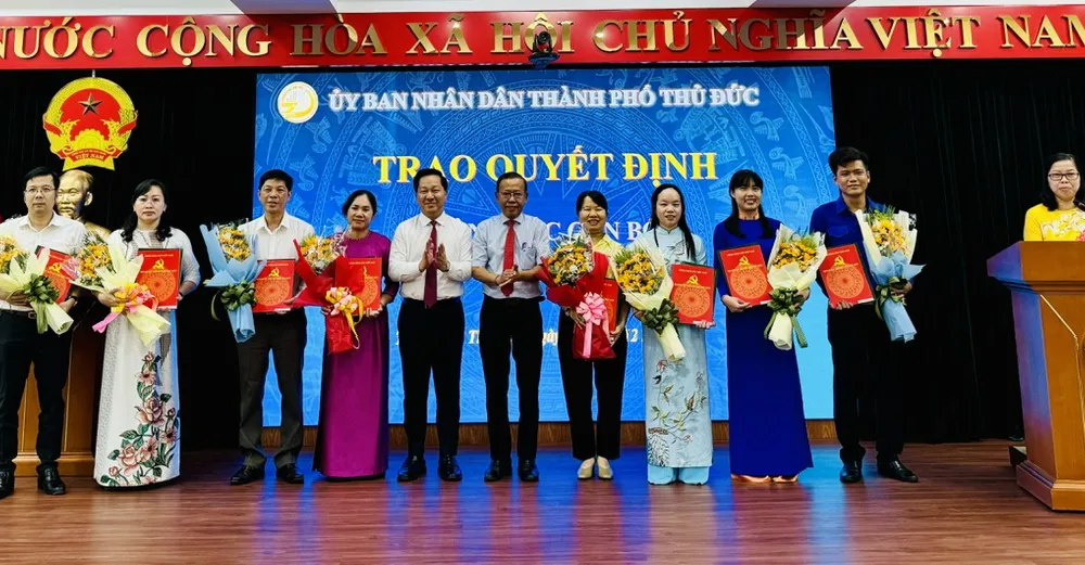Đồng chí Nguyễn Hữu Hiệp, Ủy viên Ban Thường vụ Thành ủy TPHCM, Bí thư Thành ủy TP Thủ Đức và Chủ tịch UBND TP Thủ Đức Hoàng Tùng tặng hoa chúc mừng các đồng chí nhận nhiệm vụ Phó Chủ tịch UBND các phường trên địa bàn TP Thủ Đức. Ảnh: CHÍ THẠCH