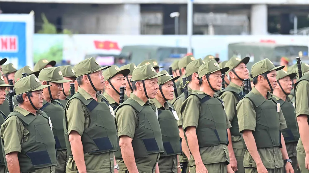 Lực lượng tham gia bảo vệ an ninh trật tự ở cơ sở tại buổi ra quân sáng 1-7. Ảnh: VIỆT DŨNG