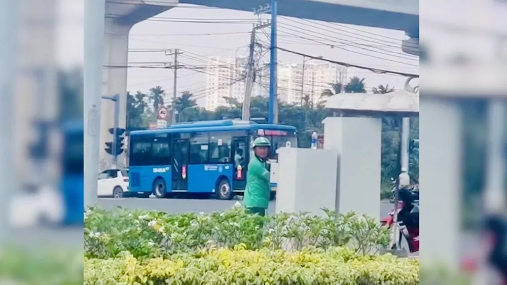 Hình ảnh người đàn ông mặc đồ GrabBike chỉnh tín hiệu đèn giao thông ở TP Thủ Đức
