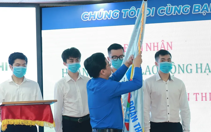 Bí thư thứ nhất Trung ương Đoàn Nguyễn Anh Tuấn thừa lệnh Chủ tịch nước gắn Huân chương lao động hạng Ba lên lá cờ của Tập đoàn Thiên Long
