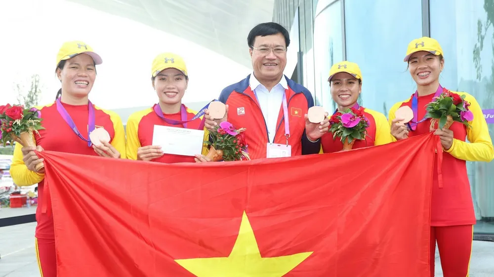 Đội rowing giành HCĐ và được lãnh đạo Đoàn thể thao Việt Nam thưởng "nóng" khích lệ. Ảnh: LƯỢNG LƯỢNG