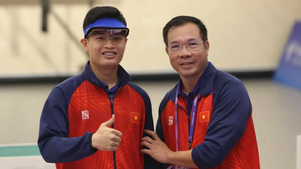 Phạm Quang Huy và HLV Hoàng Xuân Vinh sau khi giành HCV tại ASIAD 19. Ảnh: LƯỢNG LƯỢNG