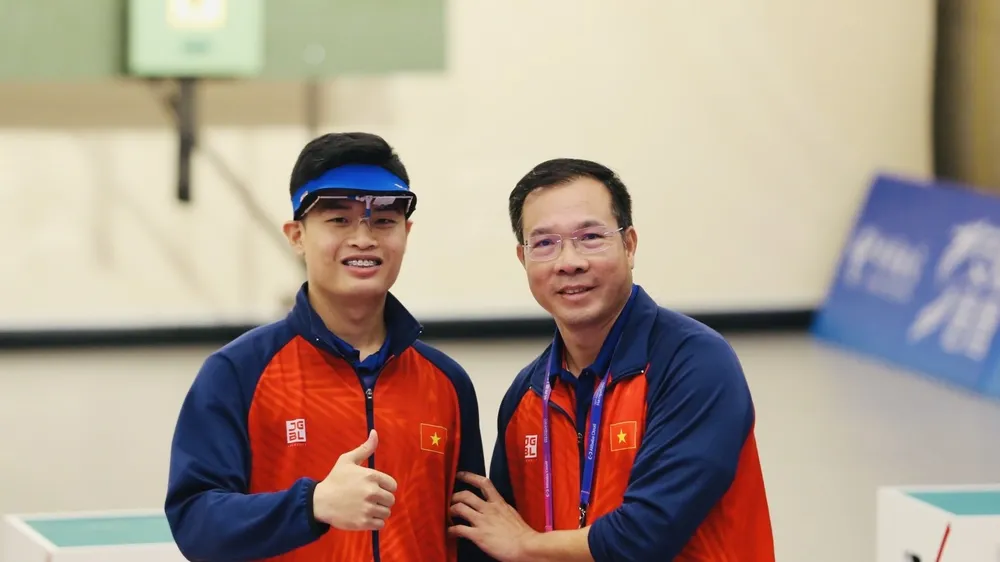 HLV Hoàng Xuân Vinh chúc mừng tuyển thủ Phạm Quang Huy sau khi giành được HCV. Ảnh: ĐOÀNTTVN