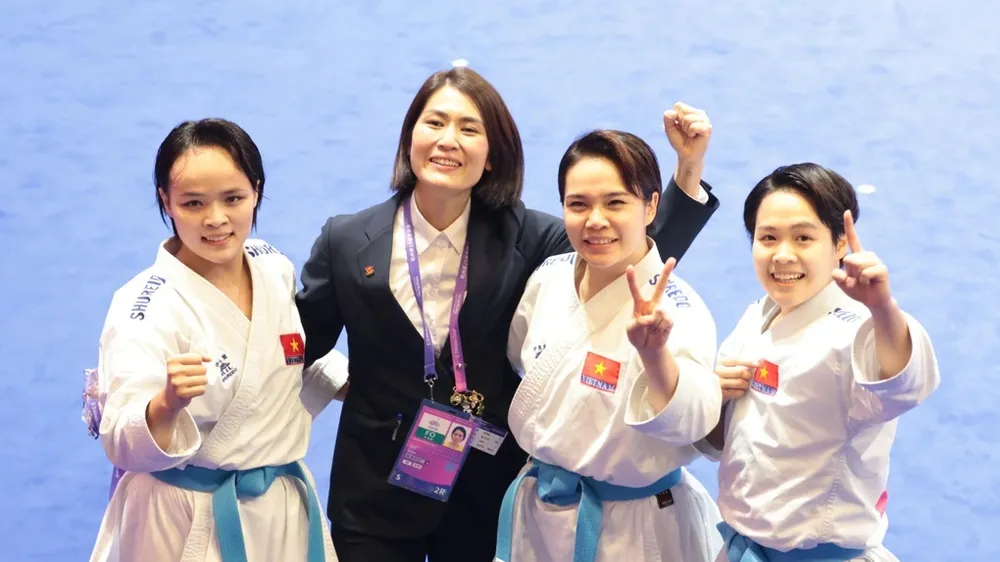 HLV Nguyễn Hoàng Ngân (áo đen) và các học trò sau khi giành HCV tại ASIAD 19. Ảnh: LƯỢNG LƯỢNG