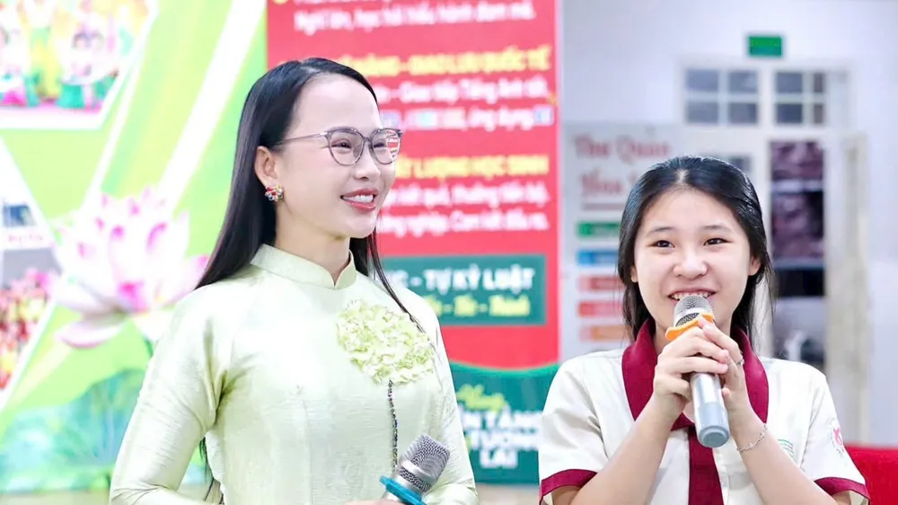 TS Nguyễn Thị Quốc Minh (trái) trong một buổi giao lưu, báo cáo chuyên đề về kỹ năng sống với học sinh.