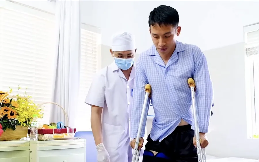 Hùng Dũng được bác sĩ dìu đi sau phẫu thuật