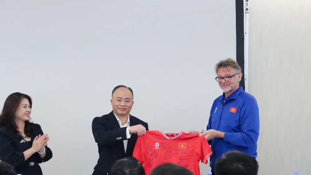 HLV trưởng Philippe Troussier thay mặt đội tuyển tặng Đại sứ quán Việt Nam tại Qatar áo thi đấu có chữ ký của các thành viên đội tuyển. 