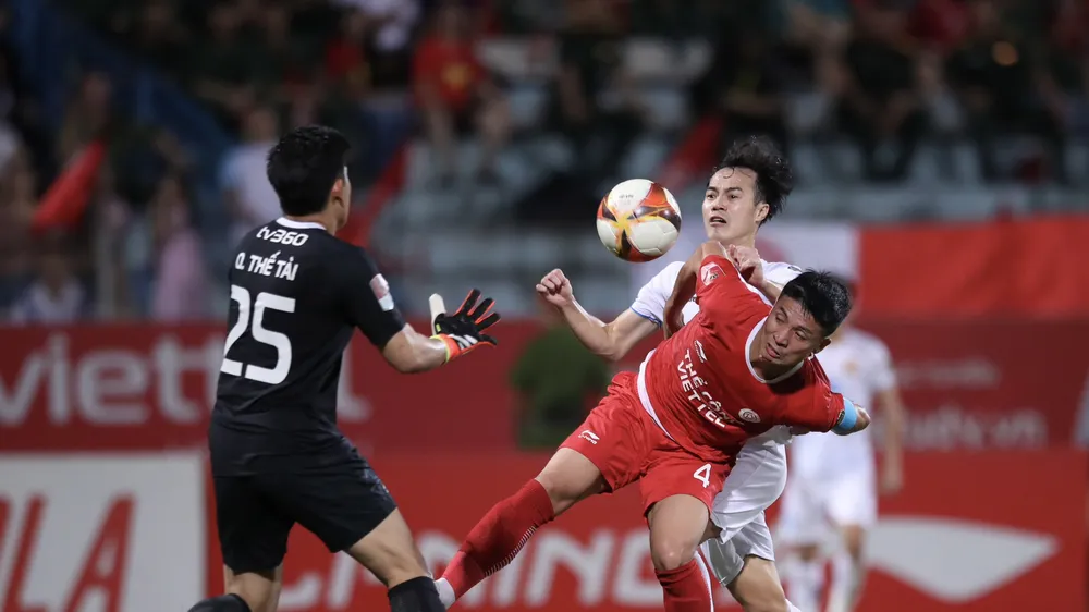 Bùi Tiến Dũng nỗ lực ngăn chận pha uy hiếp khung thành của Văn Toàn (Nam Định). Ảnh: MINH HOÀNG