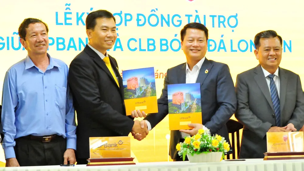 Ông Nguyễn Minh Tâm, Giám đốc Công ty CP Thể thao Long An (thứ hai từ phải sang) bắt tay cùng ông Phạm Ngọc Thủy, Giám đốc LPBank chi nhánh Long An tại lễ ký hợp đồng. Ảnh: ANH TUẤN 