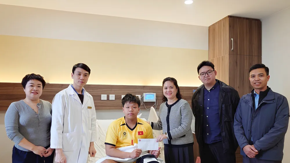 Bà Nguyễn Thanh Hà (thứ 3 từ trái sang) thay mặt lãnh đạo VFF đến thăm cầu thủ Đoàn Tuấn Phong tại bệnh viện sau khi phẫu thuật thành công.