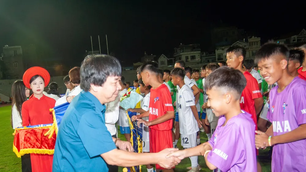 Ban tổ chức giải bắt tay động viên và trao cờ lưu niệm đến các đội dự giải.