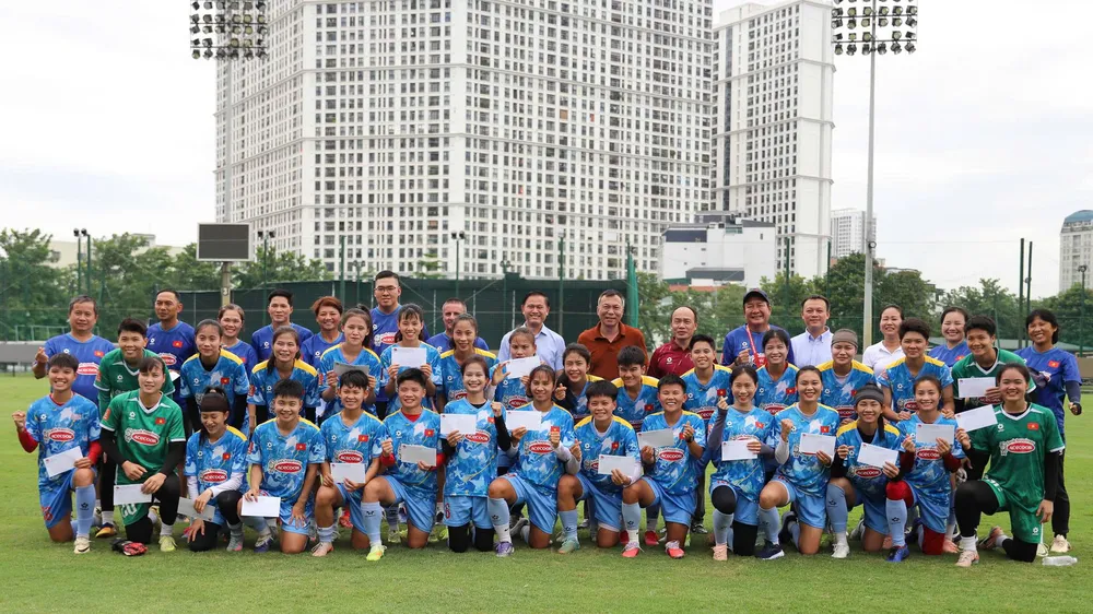 Lãnh đạo VFF chụp hình lưu niệm cùng đội tuyển nữ Việt Nam trên sân tập ngày 31-8. Ảnh: ĐOÀN NHẬT