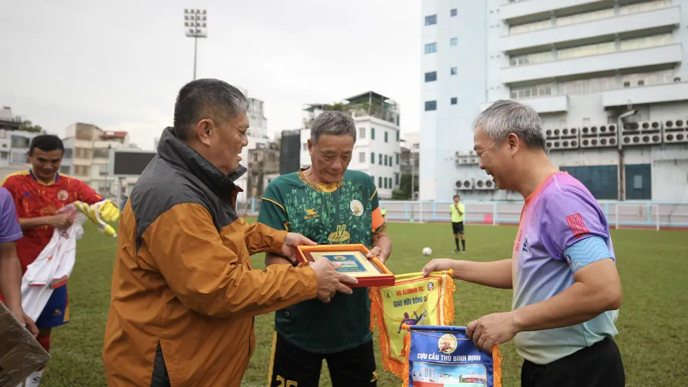 Ông Dương Ngọc Hùng trao tặng quà và cờ lưu niệm đến cầu thủ hai đội. Ảnh: DŨNG PHƯƠNG
