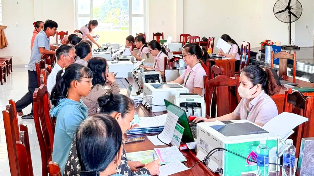 Thực hiện thủ tục giải ngân cho người vay vốn. Ảnh: THÀNH HUY