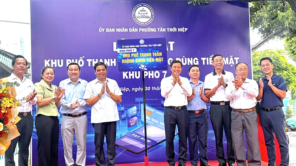 Lãnh đạo phường phường Tân Thới Hiệp cùng các đại biểu thực hiện nghi thức ra mắt "Khu phố thanh toán không dùng tiền mặt". ẢNH: THANH DUNG 