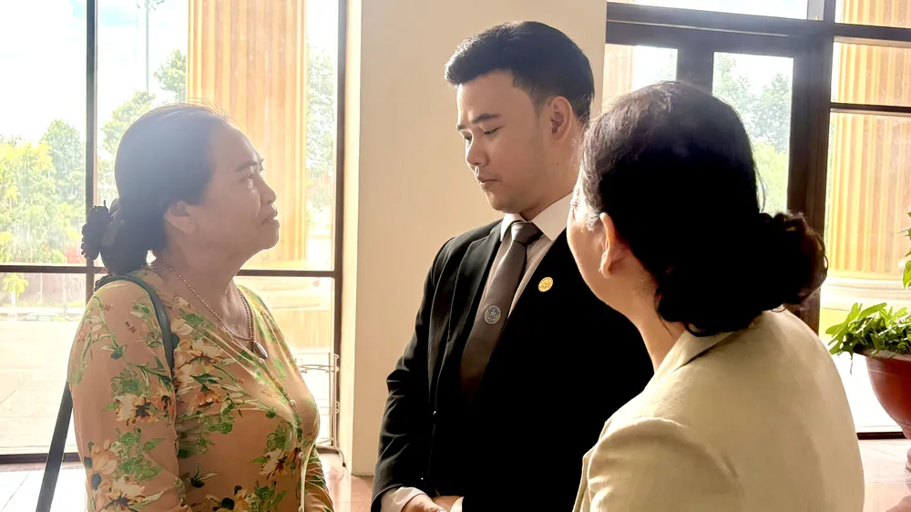 Mẹ của cố diễn viên Đức Tiến (bìa trái) trao đổi với luật sư sau phiên tòa. Ảnh: SONG MAI