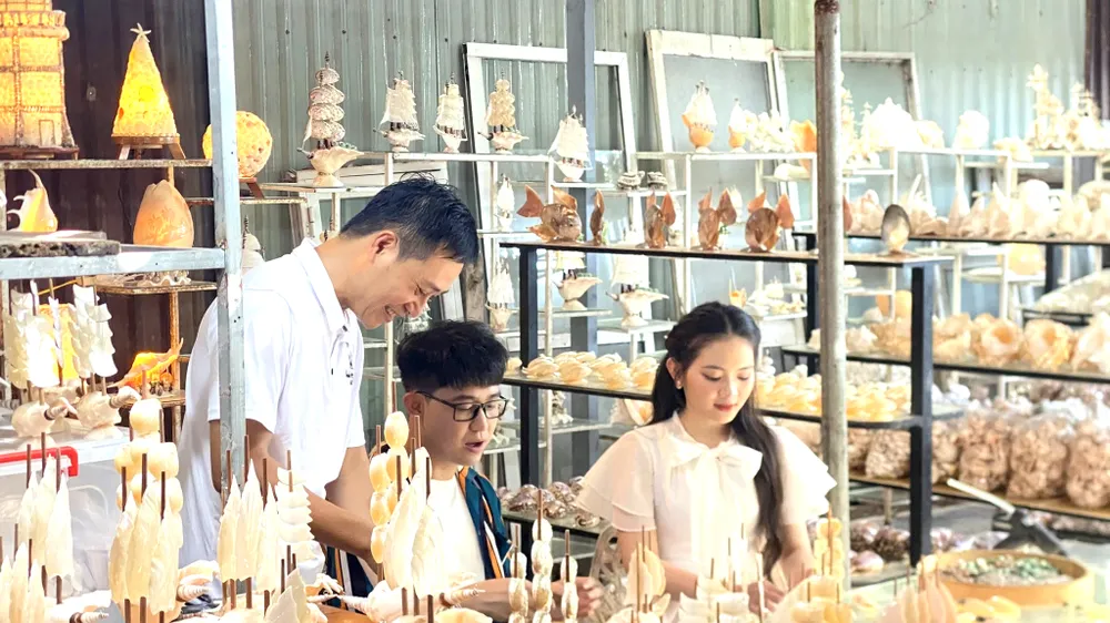 Anh Nguyễn Thanh Vũ (bía trái) nối nghiệp gia đình, tiếp tục hành trình với sò ốc mỹ nghệ.