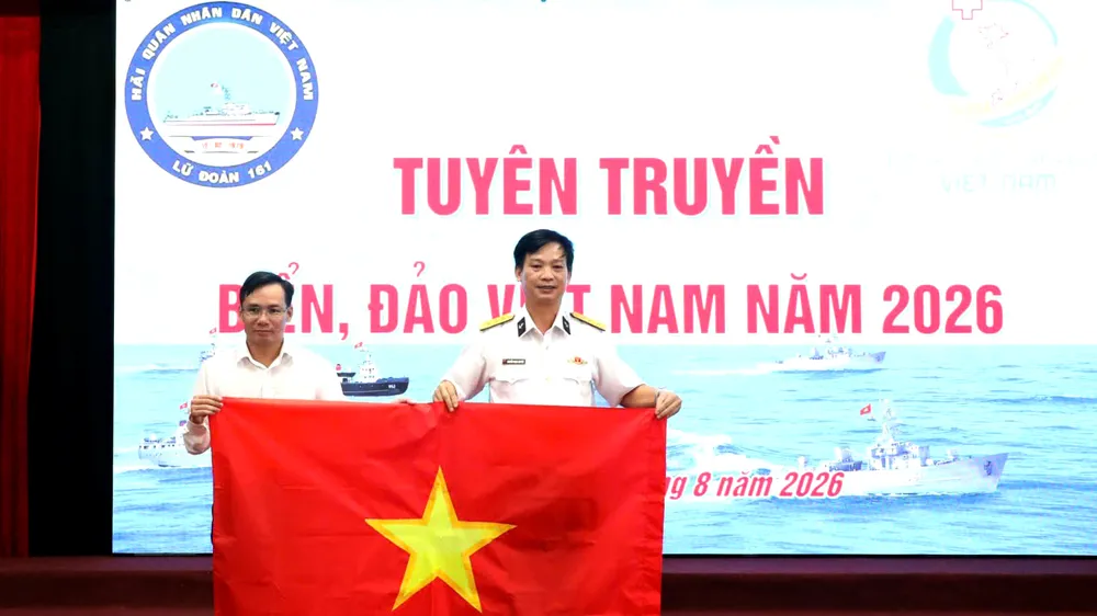 Tại chương trình, Trường Cao đẳng Công nghệ Y - Dược Việt Nam trao tặng Lữ đoàn 161 Hải quân 100 là cờ Tổ quốc. Ảnh: XUÂN QUỲNH