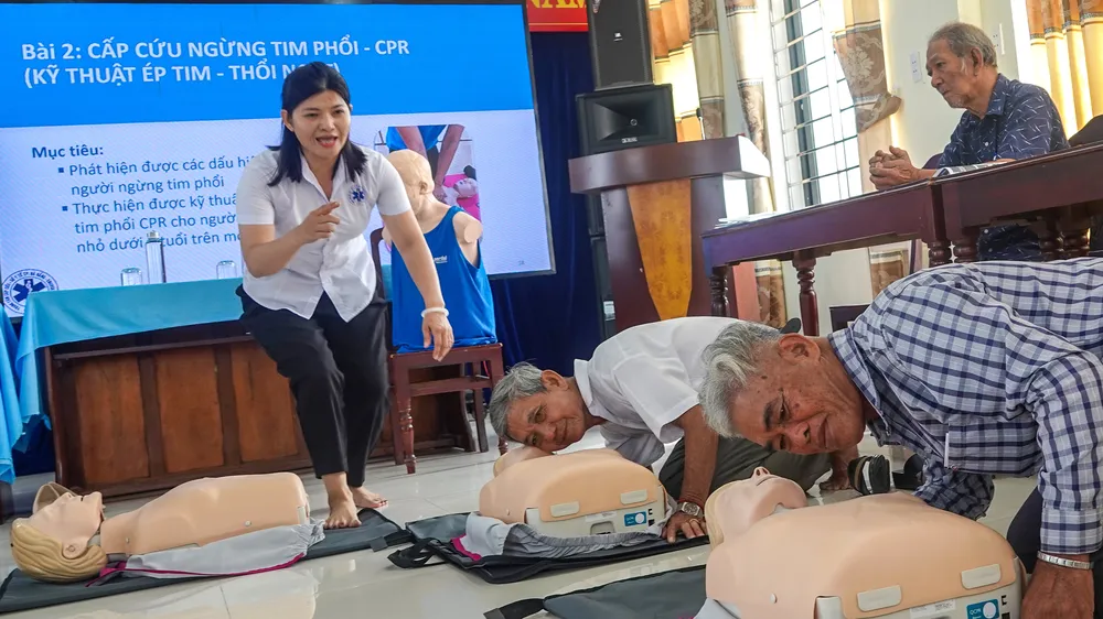 Cán bộ y tế hướng dẫn nghe nhịp thở của người bị nạn. Ảnh: XUÂN QUỲNH