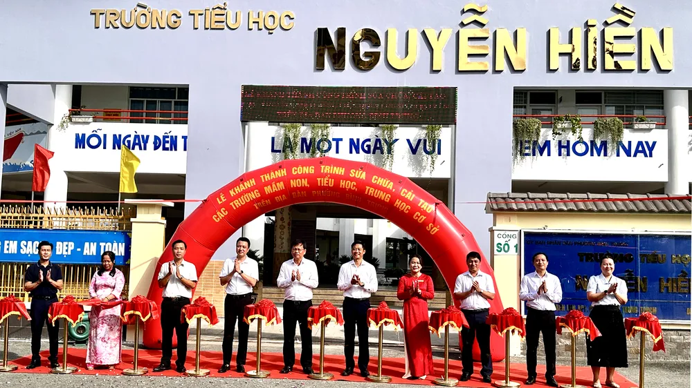 Lãnh đạo phường Bình Trưng và đại diện các trường học thực hiện nghi thức cắt băng khánh thành. Ảnh: HỒ SƠN