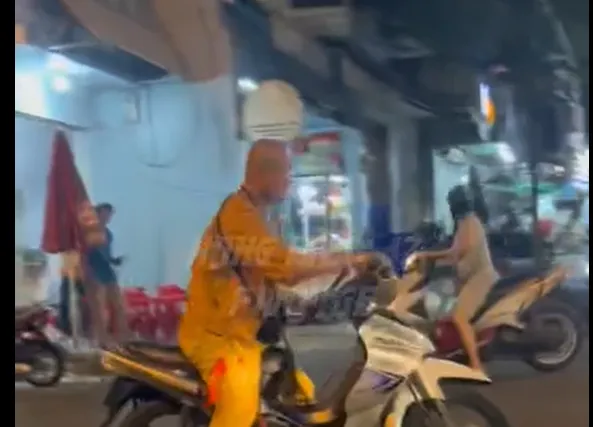 Một người mặc áo nhà tu chạy xe máy lạng lách, đánh nhau với người đi đường