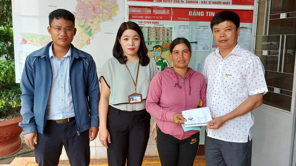 Ông Nguyễn Hữu Quế (bên phải), Chủ tịch UBND TP Pleiku phối hợp với đại diện Báo SGGP (bên trái) cùng UBND phường Trà Bá (thứ 2 từ trái qua) trao tiền hỗ trợ của bạn đọc Báo SGGP cho gia đình em Liên