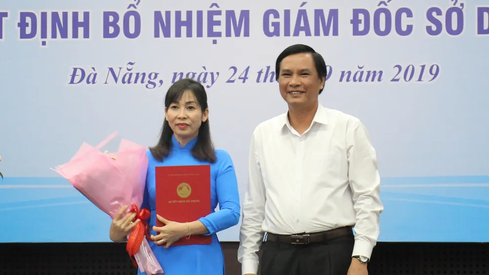 Ông Trần Văn Miên, Phó chủ tịch UBND TP Đà Nẵng trao quyết định và tặng hoa chúc mừng cho bà Trương Thị Hồng Hạnh