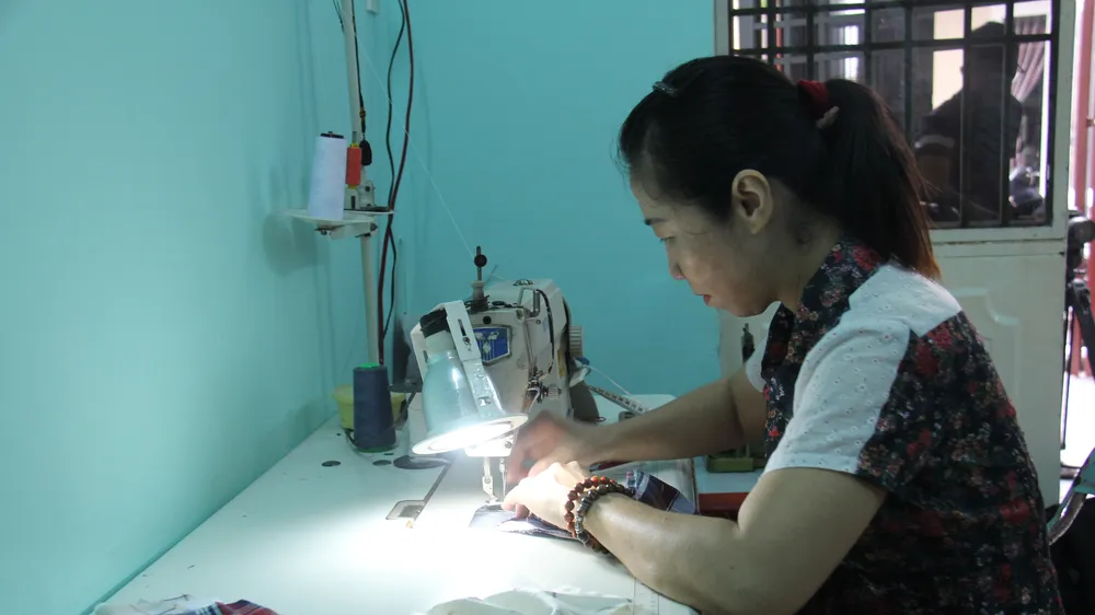 Bà Võ Thị Phương Lan đang miệt mài may những chiếc khẩu trang tại nhà