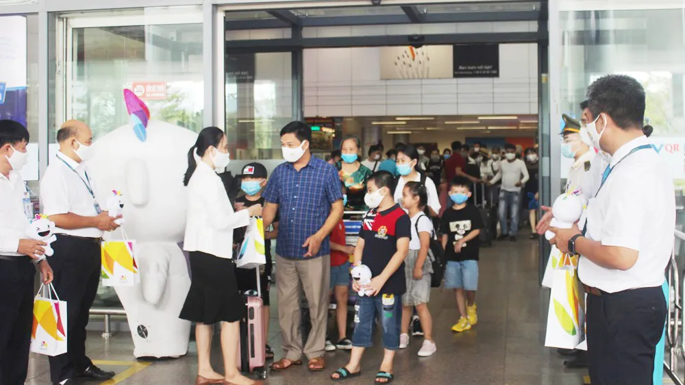 Tại Sân bay quốc tế Đà Nẵng, Đại diện Sở Du lịch Đà Năng tặng quà cho đoàn du khách đầu tiên trở lại du lịch thành phố sau dịch Covid-19