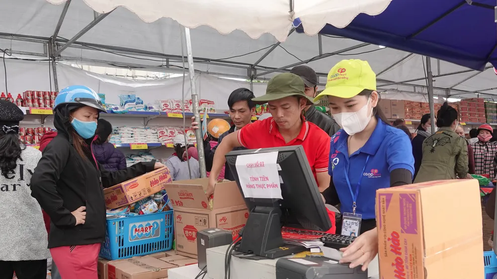 Mỗi hộ dân được trao tặng phiếu mua hàng có trị giá 1,000,000 đồng để mua hàng. Ảnh: XUÂN QUỲNH