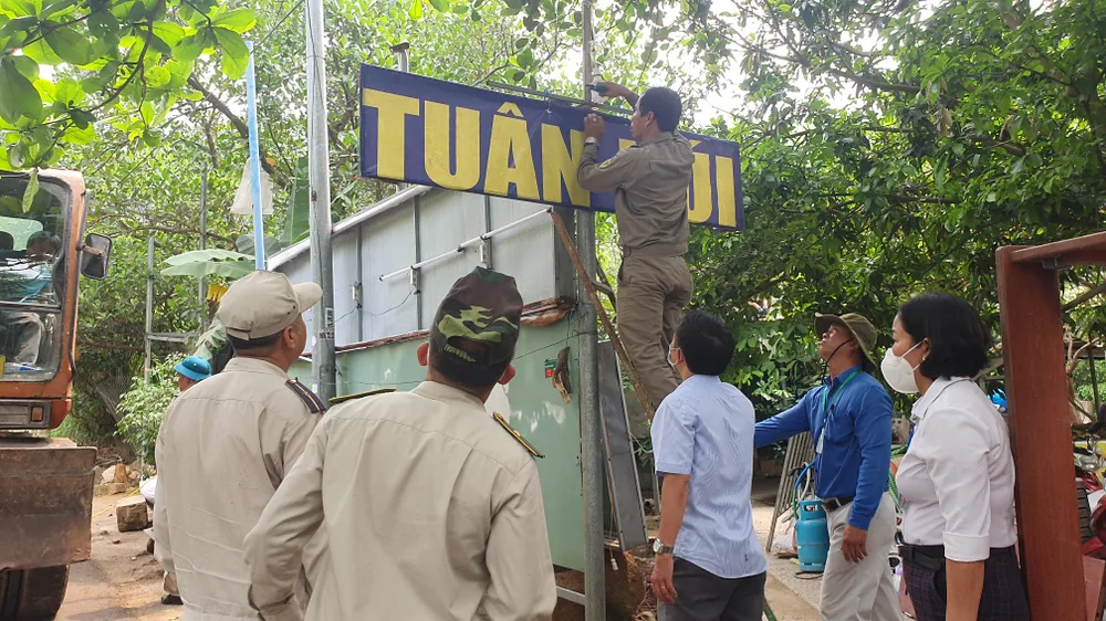 Lực lượng chức năng quận Sơn Trà tiến hành gỡ bảng hiệu "Tuân Núi". Ảnh: XUÂN QUỲNH