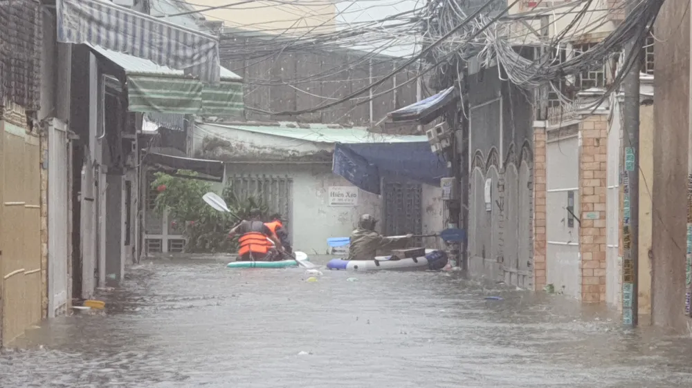 Lực lượng chức năng tiếp cận người dân khu ngập lụt bằng phao cứu sinh. Ảnh: XUÂN QUỲNH