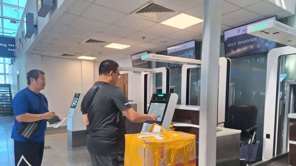 Du khách tự ký gửi hành lý tại quầy ký gửi tự động. Ảnh: XUÂN QUỲNH
