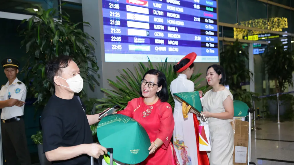 Nhân viên Trung tâm Xúc tiến Du lịch Đà Nẵng tặng quà lưu niệm cho du khách tại sân bay Đà Nẵng