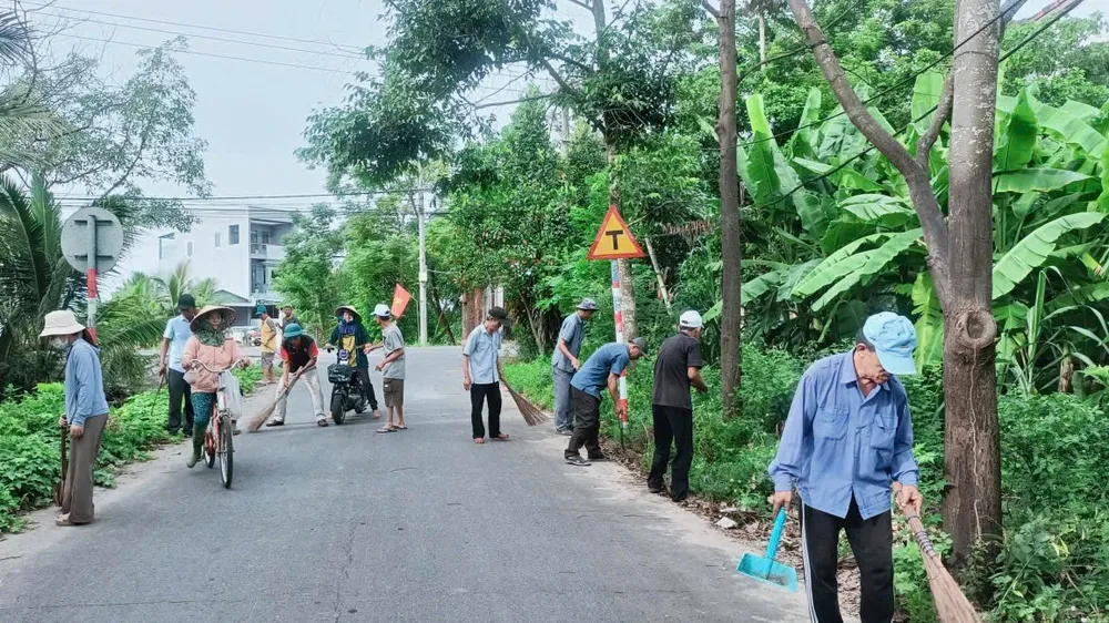 Người dân chung tay dọn vệ sinh tuyến đường, góp phần xây dựng nông thôn mới văn minh