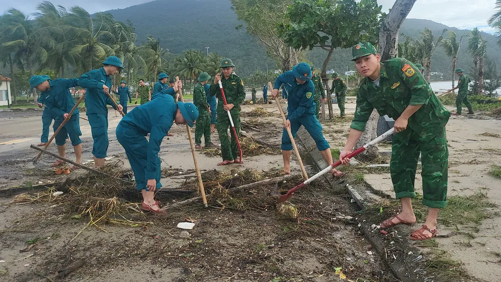 Lực lượng chức năng dọn rác tấp đầy đường ven biển Sơn Trà sau bão số 13. Ảnh: XUÂN QUỲNH