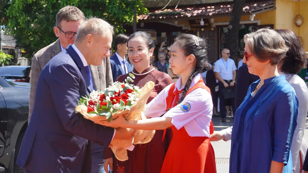 Học sinh tặng hoa chào mừng Thủ tướng Ba Lan Donald Tusk đến tham quan phố cổ Hội An