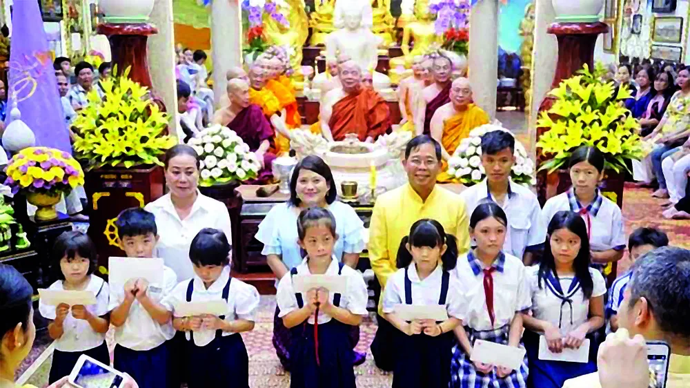 Tổng Lãnh sự Thái Lan tại TPHCM Apirat Sugondhabhirom (áo vàng) trao học bổng cho học sinh nghèo tại chùa Phổ Minh (TPHCM)