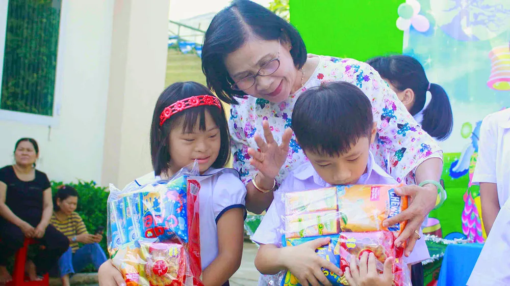 Cô Nguyễn Thị Thu Hà, Giám đốc Trung tâm Nuôi dạy trẻ khuyết tật Võ Hồng Sơn, trao quà cho trẻ khuyết tật