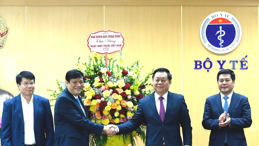 Thượng tướng Nguyễn Trọng Nghĩa, Bí thư Trung ương Đảng, Trưởng ban Tuyên giáo Trung ương tặng hoa cho Bộ trưởng Bộ Y tế Nguyễn Thanh Long. Ảnh: VGP