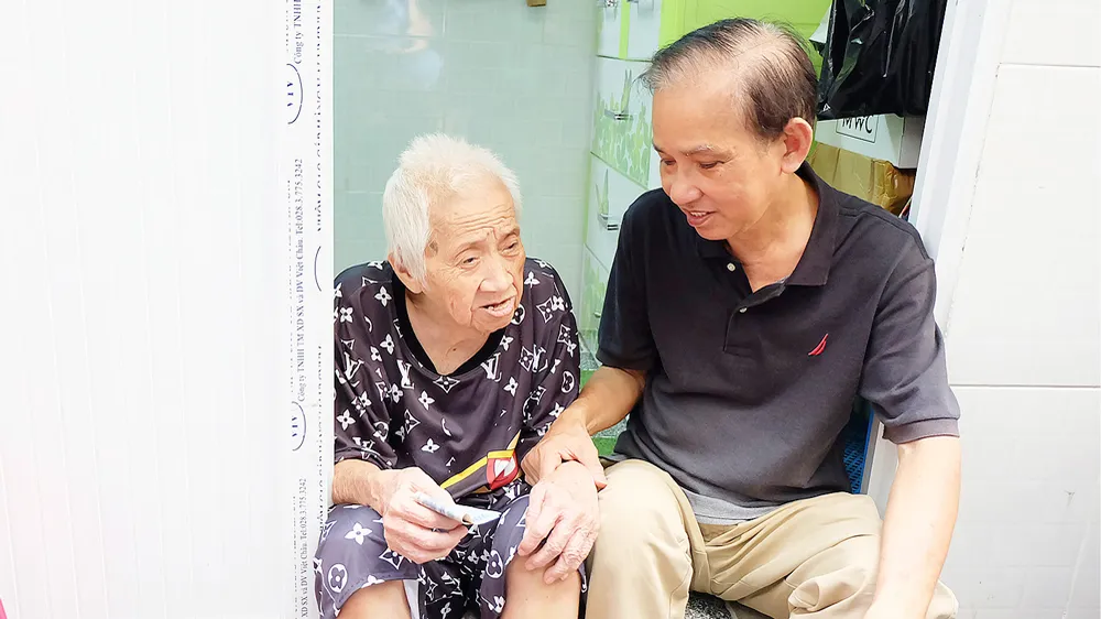 Ông Trần Văn Thanh thăm hỏi bà Trần Thị Bạch Yến, người mới được ông giúp sửa chữa nhà