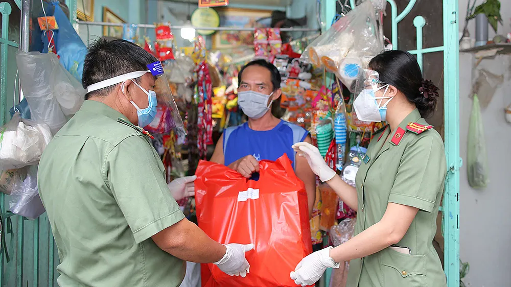 Công an quận 4, TPHCM tặng quà cho người nghèo bị ảnh hưởng bởi dịch Covid-19. Ảnh: DŨNG PHƯƠNG