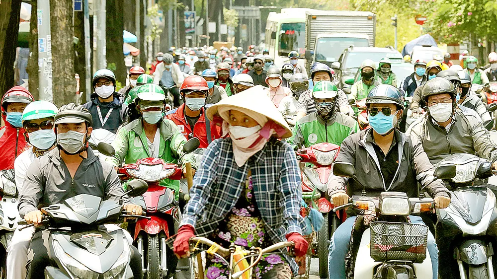 Người dân ở TPHCM đeo khẩu trang khi tham gia giao thông để phòng chống dịch Covid-19 và có cái tết an toàn. Ảnh: DŨNG PHƯƠNG