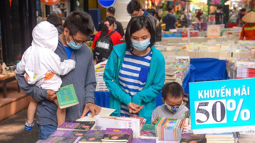 Mẹ và con cùng chọn mua sách. Ảnh: DŨNG PHƯƠNG