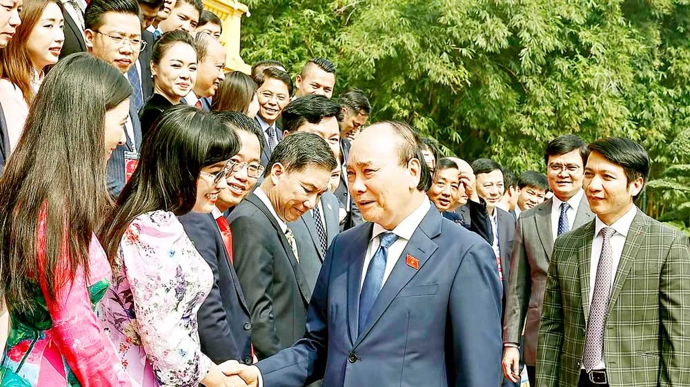 Chủ tịch nước Nguyễn Xuân Phúc với các doanh nhân trẻ. Ảnh: TTXVN